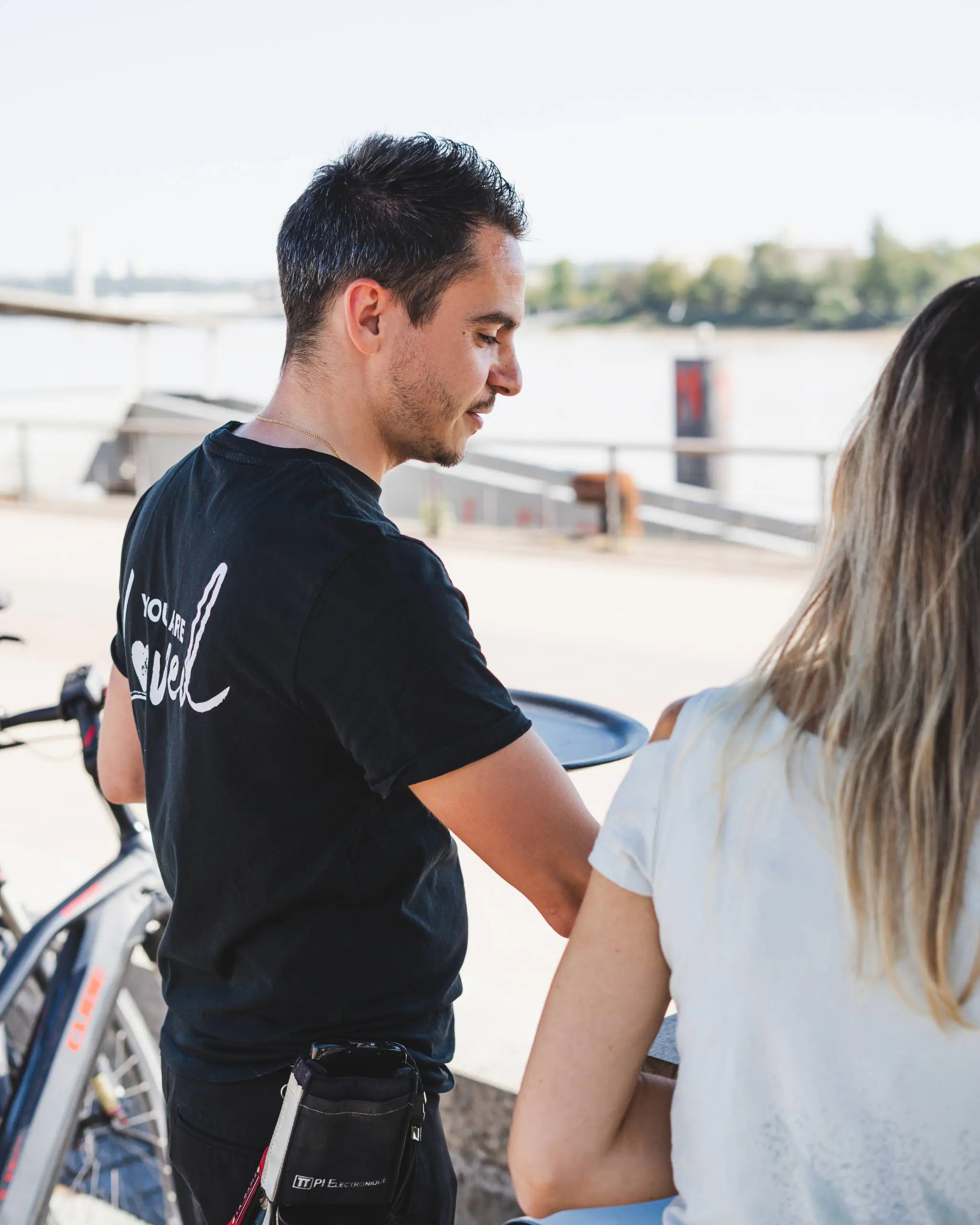 Serveur apportant une commande à des clients en terrasse au restaurant Ibaïa Bordeaux