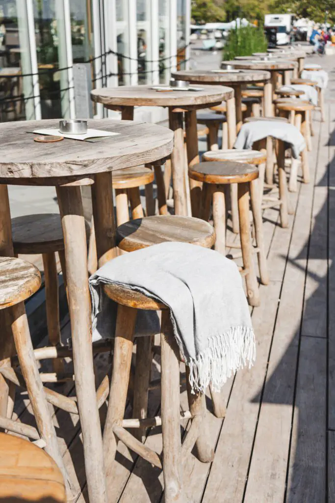 Tables hautes en bois sur la terrasse du restaurant Ibaïa Bordeaux