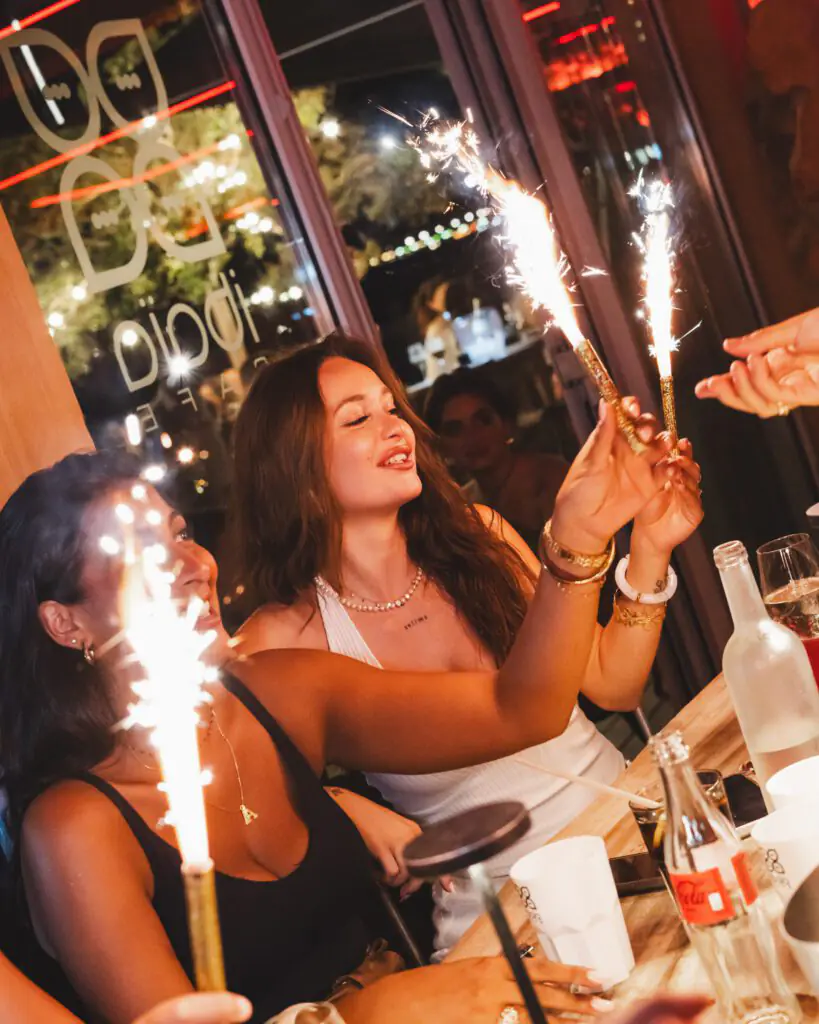 Femmes célébrant avec des étincelles lors d’une soirée au restaurant Ibaïa Bordeaux